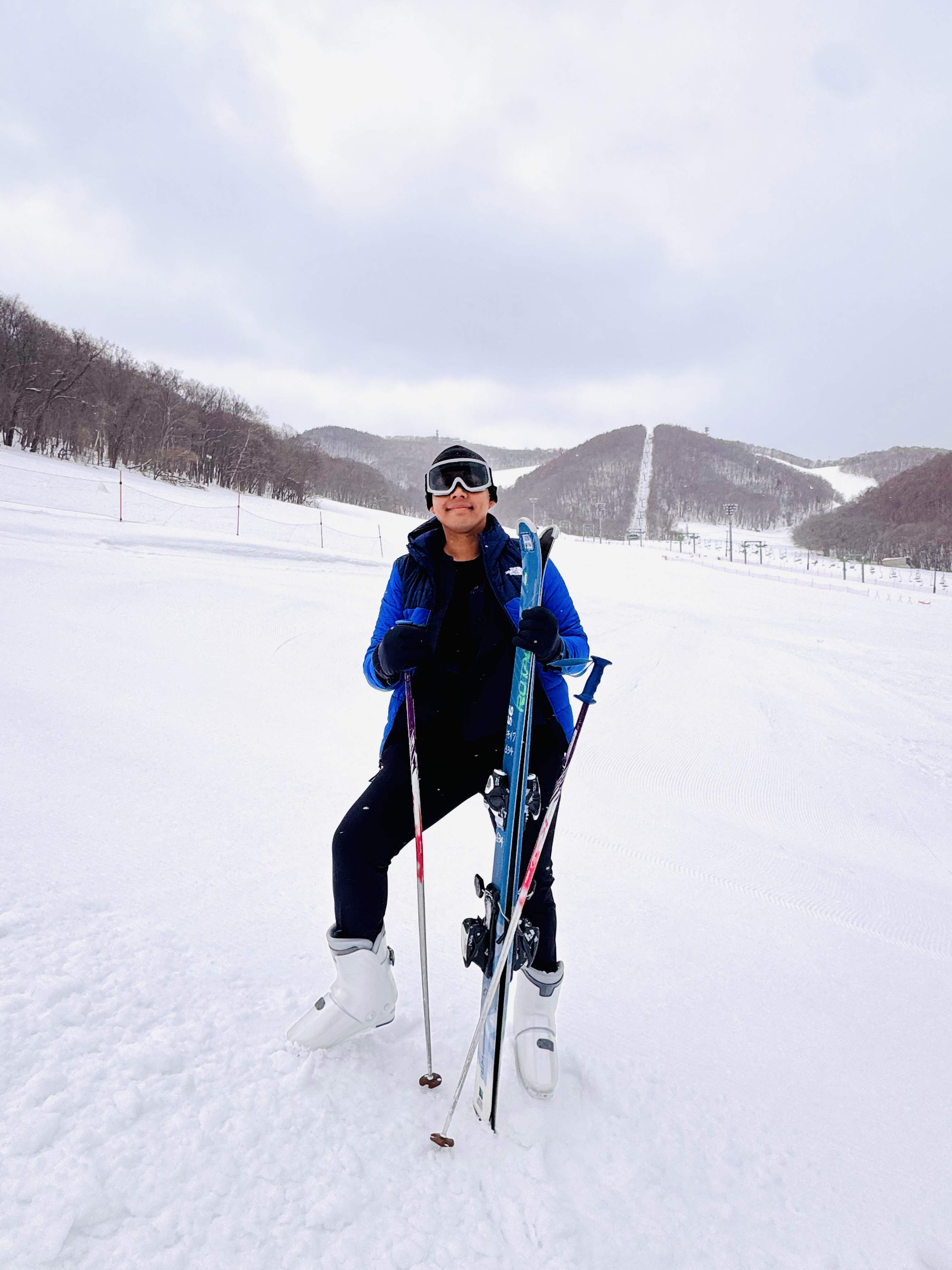Full body photo with ski equipment and snow mountains